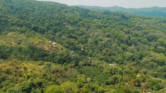 Lush green Costa Rican hills with scattered rural homes and winding dirt roads