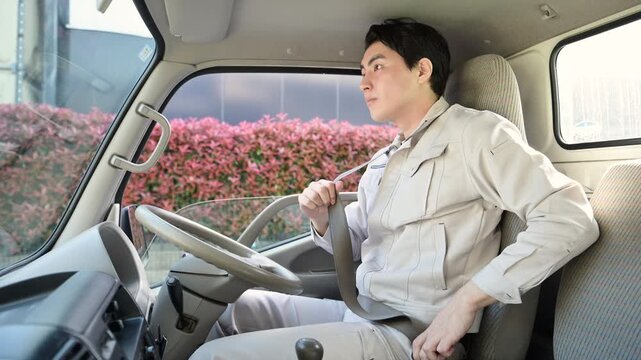 作業員が車内でシートベルトを着用する安全運転と配達や輸送などの通勤イメージ　配送業もご安全に！の動画