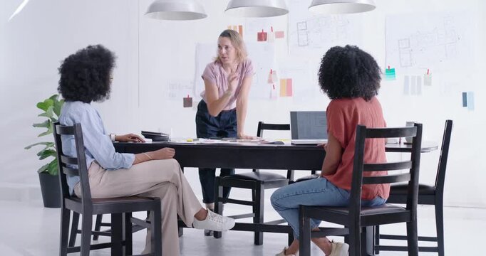 Female team watching presenter moving to black table in studio, arranging samples for final layout
