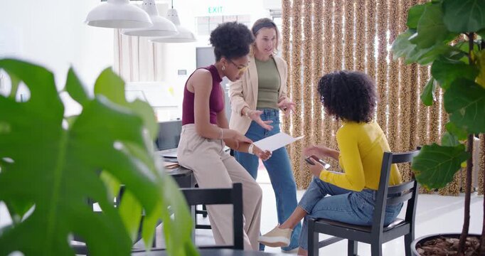 Diverse female team at office standing woman leading, explaining plans while peers checking phone