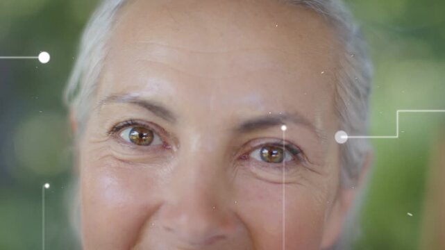 Senior woman slowly smiling while nodes popping and aligning over face, driving health tech mapping