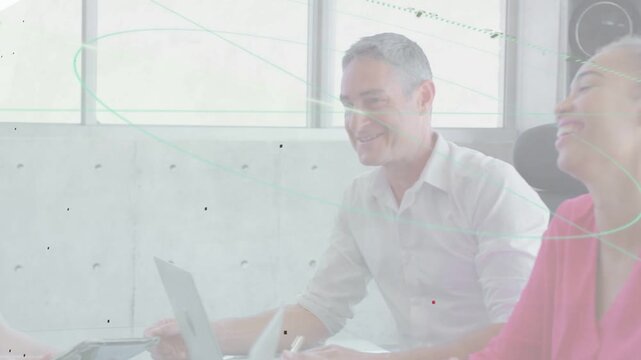 Woman holding tablet tapping screen in business meeting, overlays marking laptops, team celebrating
