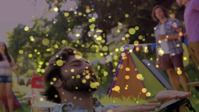 Events drummer reclining tapping drum raising beat gold dots drifting over lens playing for group
