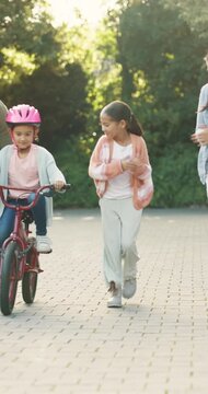 Family, applause and girl with bicycle in backyard, support or guidance for coordination development. Smile, cycling or parents with children for balance practice, outdoor or clapping for achievement