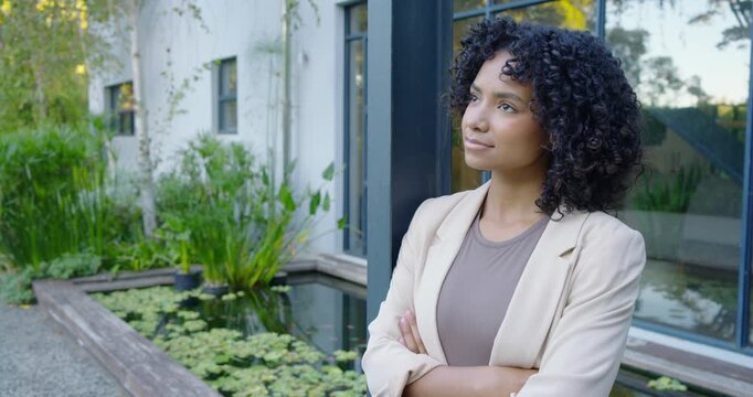Adult woman wearing blazer by post at pond, camera moving, meeting gaze conveying calm, copy space