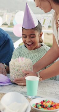 Mother, surprise and child with cake at party outdoor for birthday, celebration and gathering. Shocked, kid and wow expression for dessert, milestone congratulations and special occasion with family