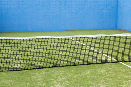 Empty Practice Tennis Court with Net on Outdoor Sports Field