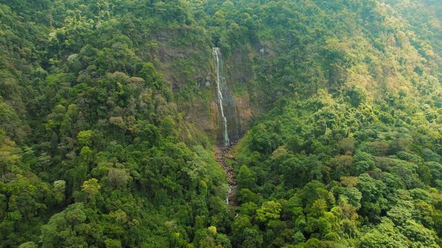 Tall waterfall dropping through lush rainforest hills in southern Costa Rica