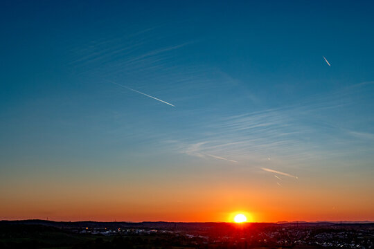 Kondensstreifen am Himmel bei Sonnenuntergang