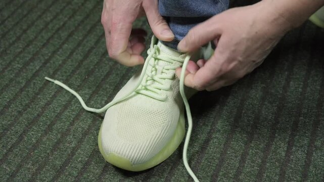 Learning to tie shoelaces in a simple step by step guide in a home setting