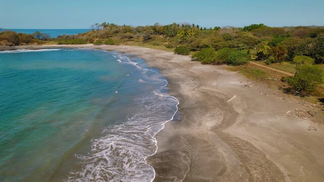 Aerial view of woman walking on tropical Pitahaya beach in Costa Rica