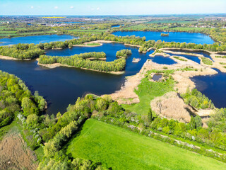 Wonderful drone photography view of many lagoons and small lakes seen in the Fen Drayton reserve in Cambridgeshire, UK. In the far distance is the market town of St Ives. © Nick Beer