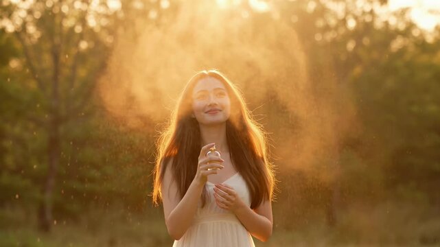 Elegant perfume spray mist dispersing in warm golden hour sunlight outdoors with gentle flowing hair and soft dress for a calm joyful ambiance cinematic video footage