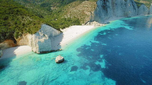 White sandy beach and turquoise waters surrounded by cliffs in Kefalonia Greece