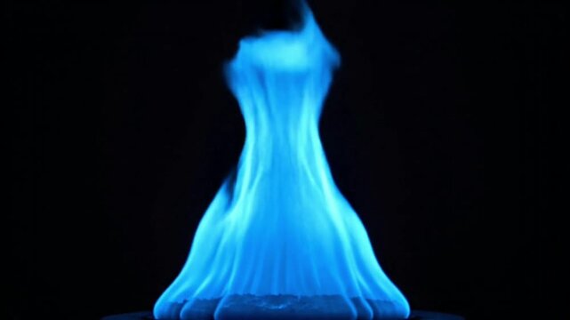 Vibrant blue flame against a dark background with warm glow