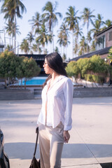 Fototapeta premium Portrait gorgeous charming relaxed Asian woman lady girl female sitting performing meditation beach sand ocean sea. Happy woman walking on beach