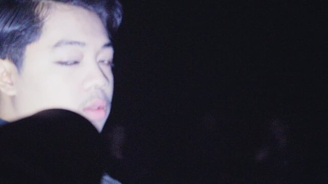 A chaotic, shaky, found-footage style close-up of a young man with his group at night. The disorienting movement and dark lighting create a raw, mysterious, and energetic vibe.