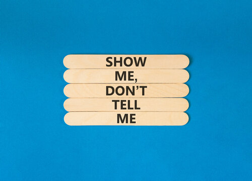 Tell or show symbol. Concept words Show me, do not tell me on beautiful wooden sticks. Beautiful blue paper background. Business tell or show concept. Copy space.