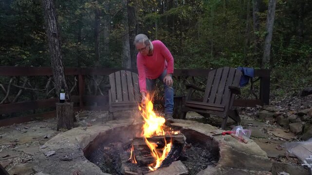 Woman building a campfire in a fire pit