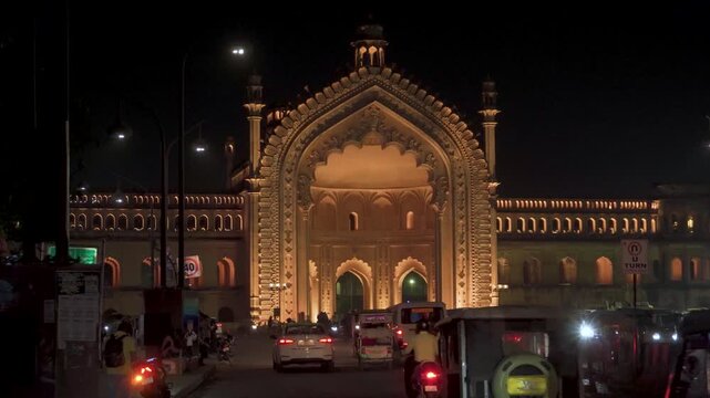 Rumi Darwaza seamlessly blends Mughal, Turkish, and Persian architectural elements. Illuminated Historic Gateway on Busy City Street at Night
