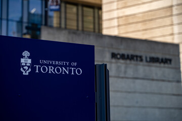 Naklejka premium Close up of University of Toronto sign with Robarts Library in background. Toronto, Canada - April 22, 2026.