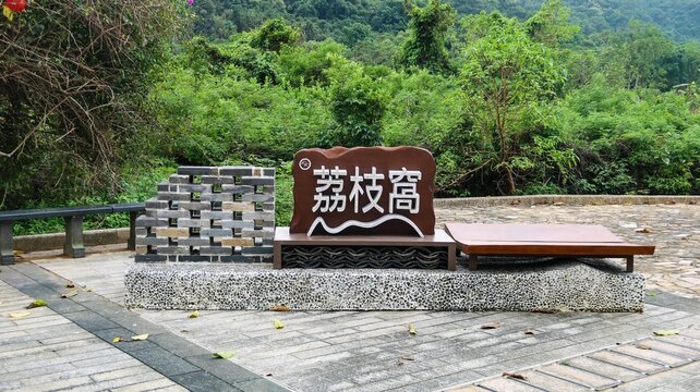 Lai Chi Wo, Sha Tau Kok, Plover Cove Country Park, New Territories, Hong Kong- 6 Apr 2026: Wooden Sign showing the name of the walled Hakka Village written in Chinese in the open area with trees at th