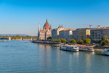 Fototapeta premium Hungarian Parliament building on Danube river in Budapest with cityscape and boats, Hungary
