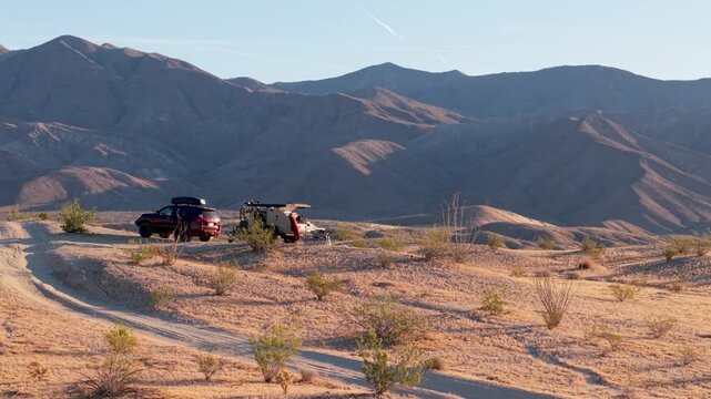 Aerial view shows a teardrop camper and SUV parked on Thimble trail in Anza Borego Desert State Park during the evening light.