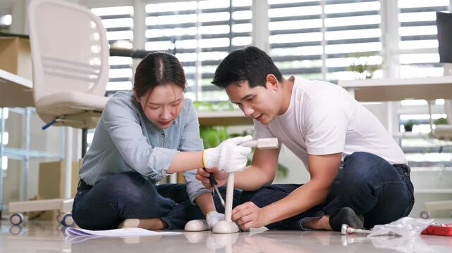 Young couple installing furniture at home.assemble furniture. Moving in new house. Self-assembly furniture concept.