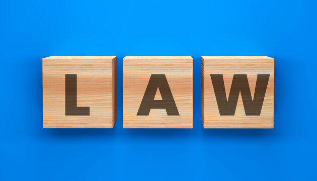 Law Cubes: The word LAW is spelled out in bold letters on three wooden cubes against a stark blue backdrop. A striking image that conveys law. 
