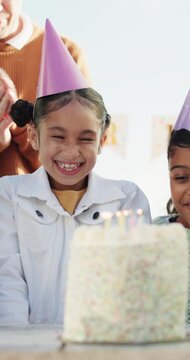 Family, singing and child with cake at birthday party for celebration, special day and wish outdoor. Happy, parents and girl with applause, hat and candles for event, gathering and song for milestone