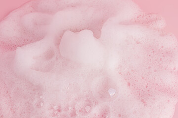 Fototapeta premium Chic white fluffy foam, soap foam texture, shampoo on a pink background. Layout for advertising detergents, spa cosmetics. A copy space