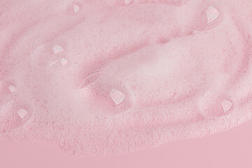 Fototapeta premium Large transparent soap bubbles, soft foam of soap, gel, detergent on a pink background. Hygiene and cleanliness concept. Top view. A copy space