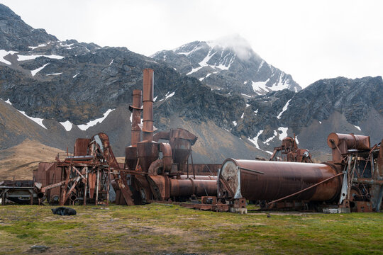 View of the rusty industrial machinery at the historic Grytviken whaling station with snow-capped mountains in the background Grytviken, South Georgia and the South Sandwich Islands.