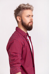 Obraz premium Pensive young man with beard blond dyed hair wearing red checkered shirt looking away with dreamy thoughtful face expression calm mood isolated over gray background