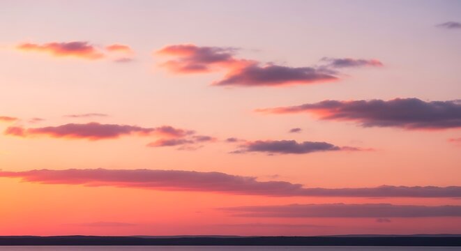 Vibrant sunset sky with soft clouds and warm, glowing colors.