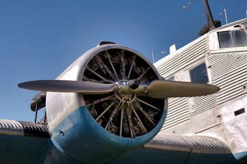 Close view of a vintage airplane propeller and engine against a clear blue sky during daytime © Piotr