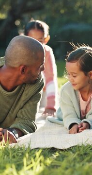 Dad, children and relax on picnic blanket at park, smile and bonding on family vacation in summer. Man, girl and kids with care, connection and love for break on grass, nature or happy on holiday