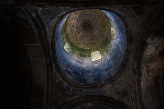 Interior view of the ancient stone dome of Gergeti Trinity Church in Georgia, Sunlight streaming through windows of medieval orthodox temple, Spiritual heritage and sacred architecture concept