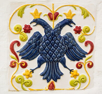 Antique majolica tiles with the image of a double-headed eagle adorn the wall of an ancient monastery