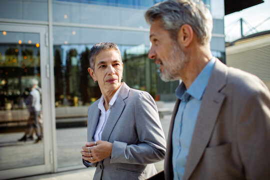 Two senior business colleagues talking outside office