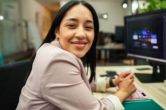 Smiling businesswoman working at computer in modern office