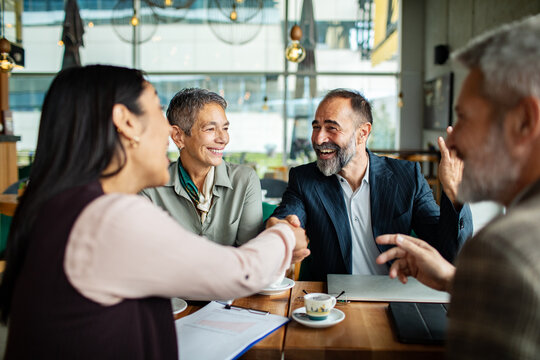 Business colleagues sealing a deal in a cafe