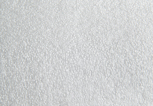 Close up texture of white polyethylene foam surface used for protective packaging inserts, custom case inlays and industrial cushioning. Closed cell PE foam material with fine detailed pattern. 