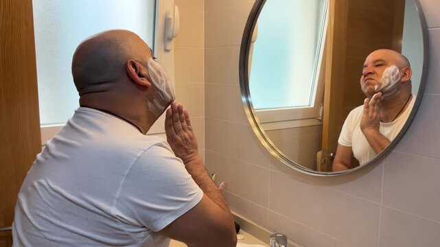 Hombre aplic&aacute;ndose jab&oacute;n de afeitar en la cara
