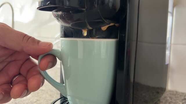 Detalle de caf&eacute; cayendo de la cafetera a la taza