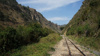 Perspective of an empty railway track passing through a rocky canyon valley © Santiago Olaya