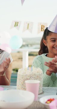 Applause, birthday and child with cake and family for celebration, gathering and special day outdoor. Happy, excited and girl with decorations, balloons and candles for cheering, milestone and party