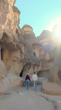 Explore the stunning rock formations and unique ancient caves of Cappadocia, Turkey as two travelers embark on a memorable journey through this breathtaking landscape under the warm sun.