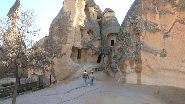 Visitors wander through the stunning rock formations of Cappadocia, Turkey, uncovering historical cave dwellings. The unique scenery creates a magical atmosphere perfect for adventure and discovery.